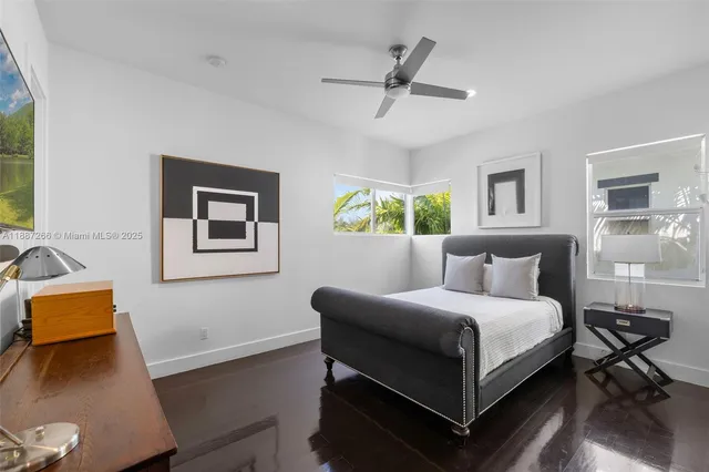 a bedroom with a bed wooden floor and window