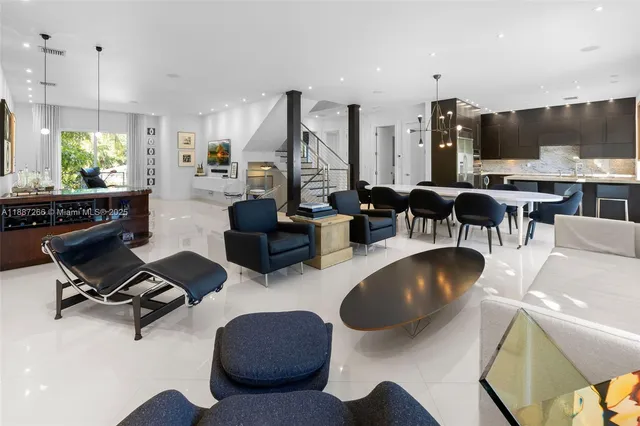 a living room with furniture kitchen view and a large window