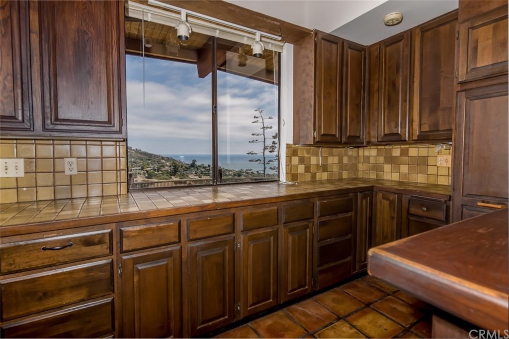 1844 Upper Rim Rock Road Laguna Beach, CA 92651 - Photo 16 of 38 a kitchen with wooden cabinets and a sink