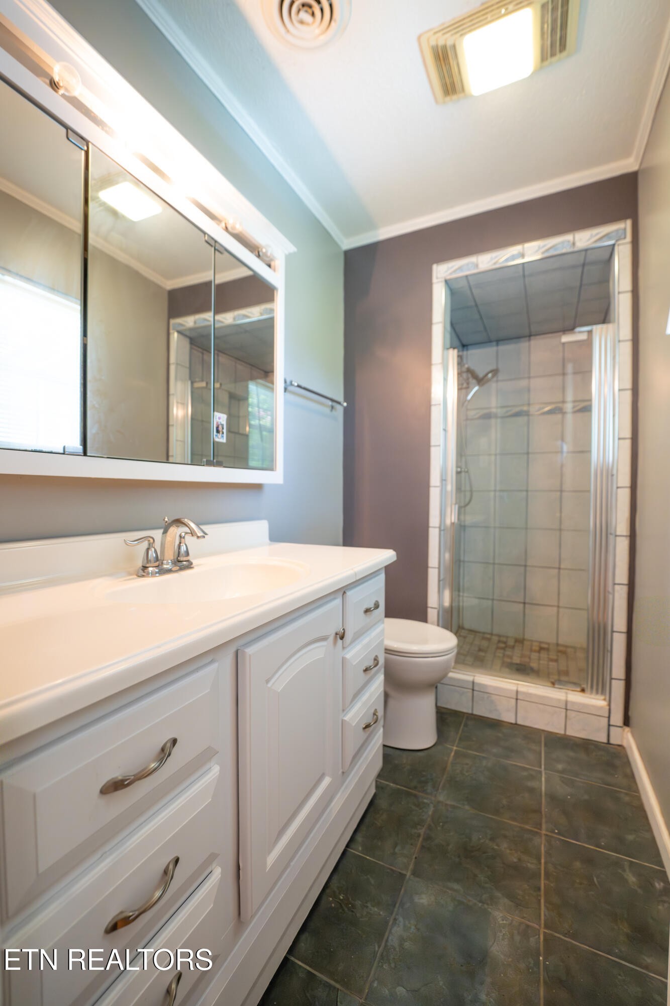 7725 Cranley Road Powell, TN 37849 - Photo 15 of 43 a bathroom with a granite countertop sink toilet a mirror and shower