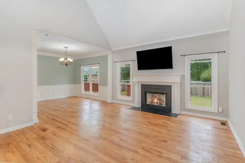 a view of a livingroom with a fireplace wooden floor and window