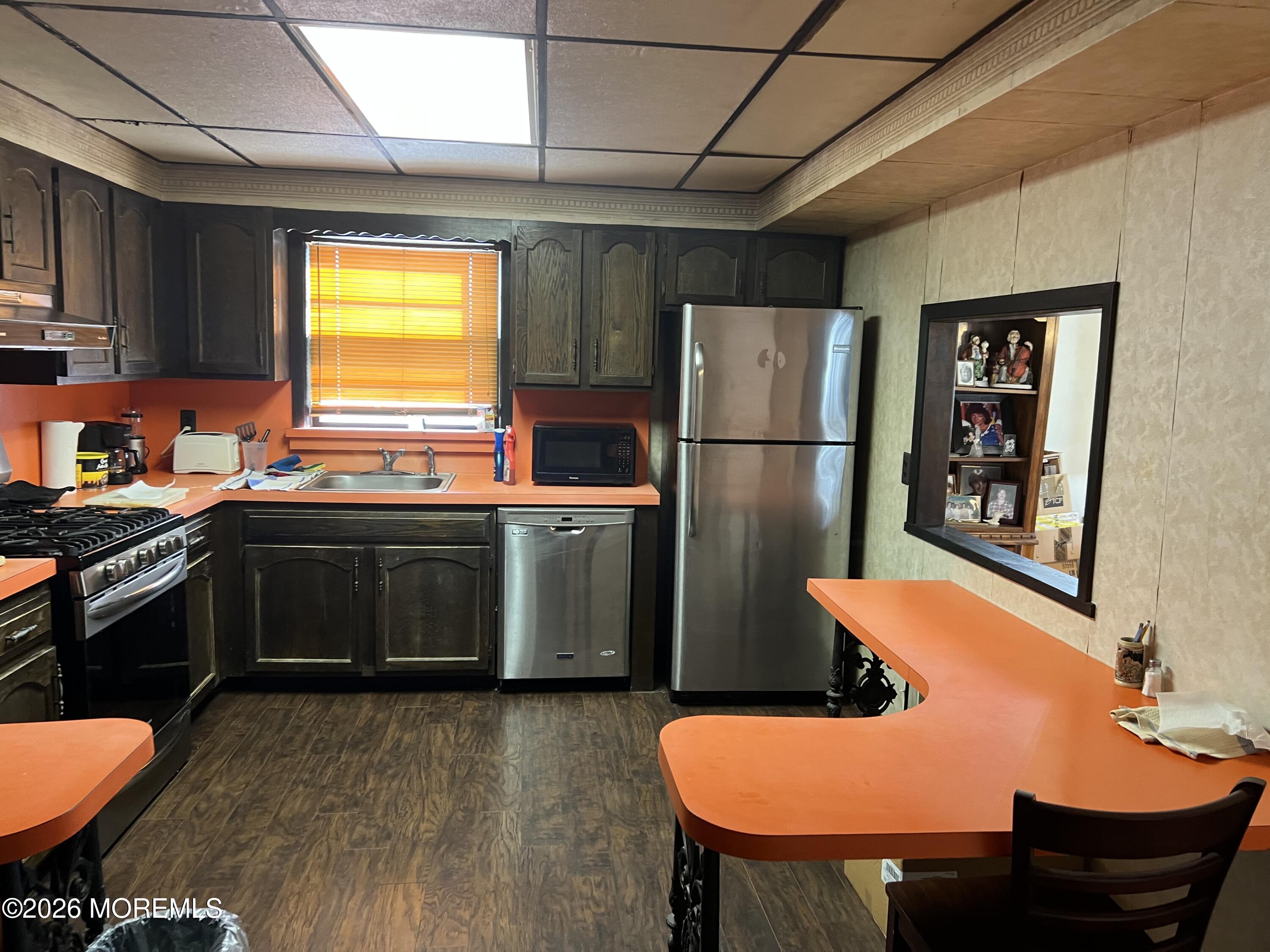 571 Hopping Road Belford, NJ 07718 - Photo 4 of 29 a kitchen with a table chairs and a refrigerator