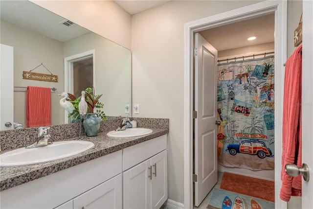 a bathroom with a granite countertop sink and a mirror
