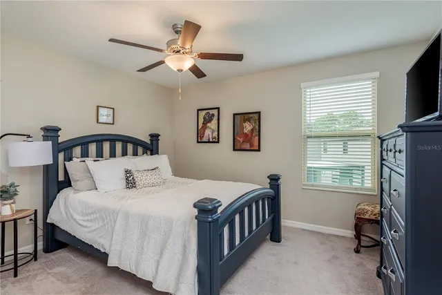 a bedroom with a bed a flat screen tv and a window