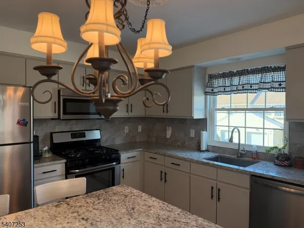 a kitchen with stainless steel appliances granite countertop a sink and cabinets