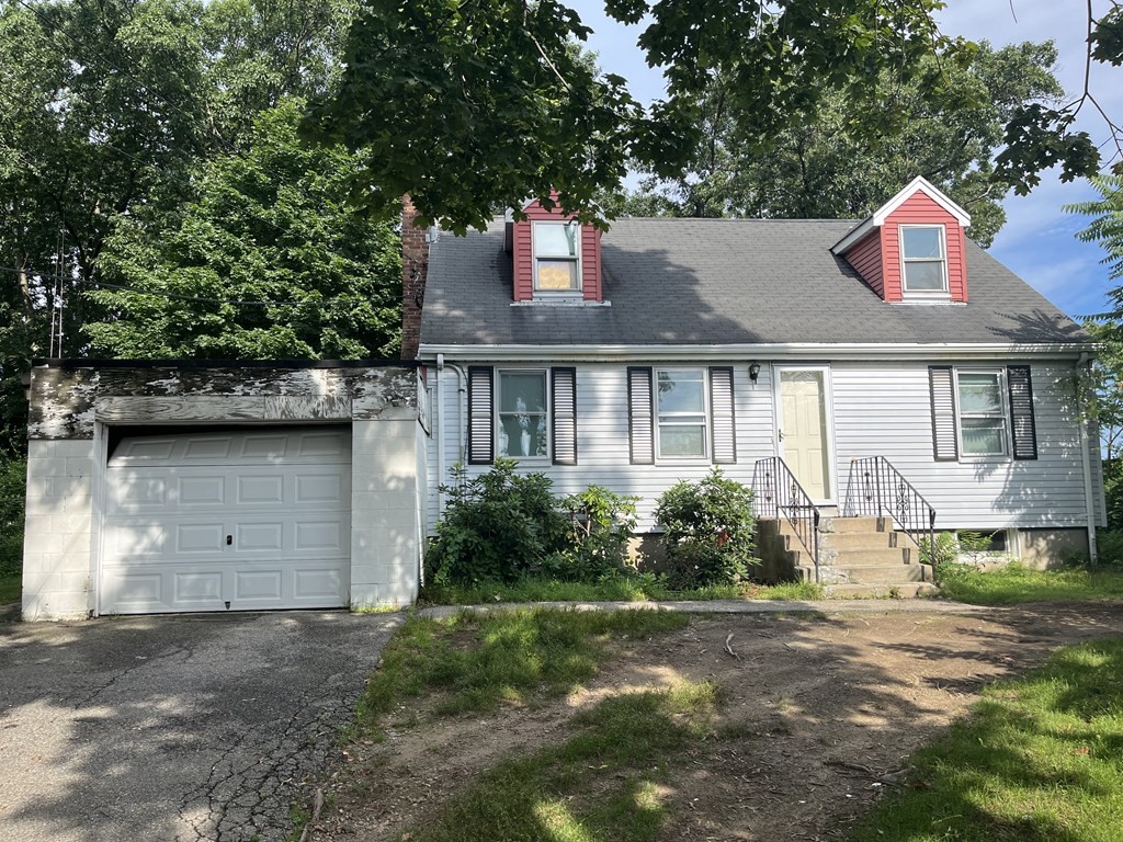 a front view of a house with a garden and plants