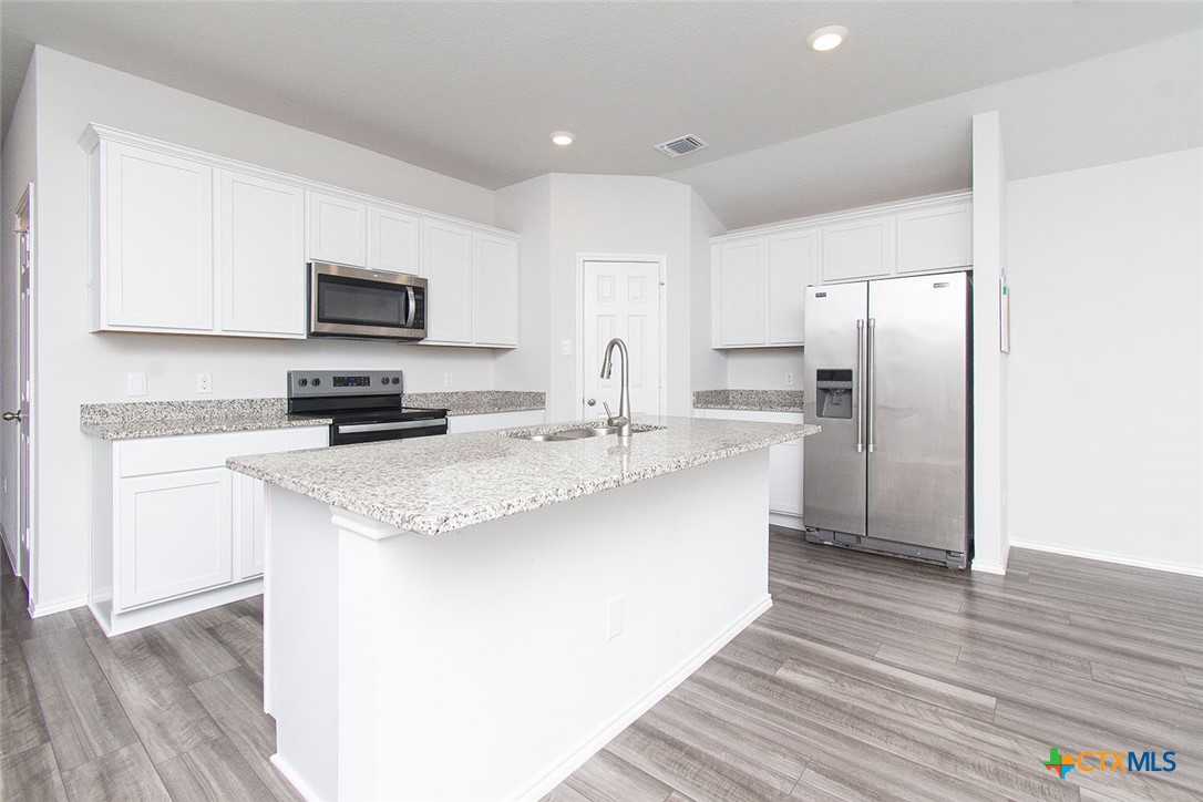 1717 Cedrus Drive Belton, TX 76513 - Photo 5 of 23 a kitchen with stainless steel appliances granite countertop a sink stove refrigerator and cabinets