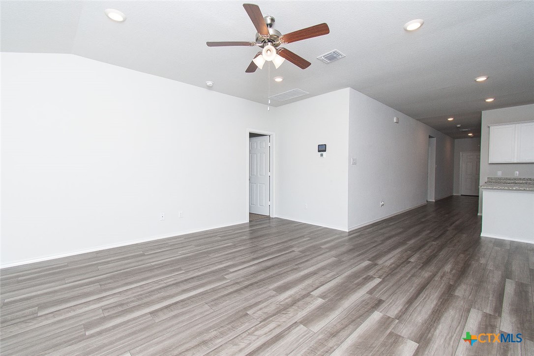 1717 Cedrus Drive Belton, TX 76513 - Photo 7 of 23 an empty room with wooden floor and a ceiling fan