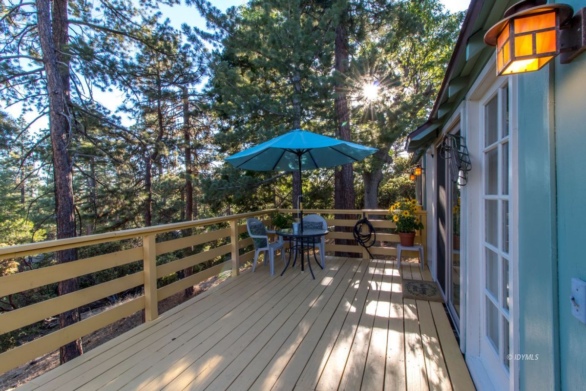 a view of a wooden chairs and table in the balcony