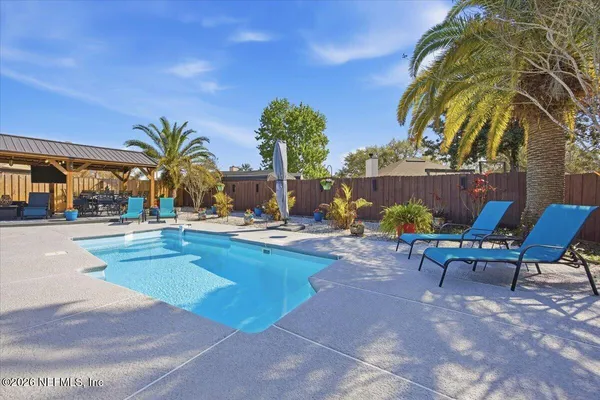 a view of swimming pool with outdoor seating and plants