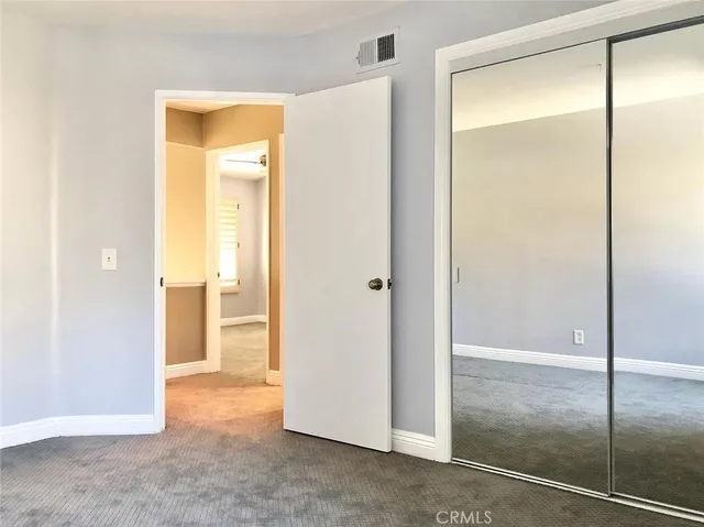 an empty room with windows and closet