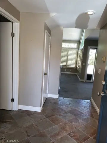 a view of an empty room with a fireplace and a window