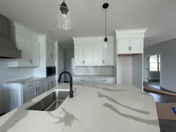 a kitchen with granite countertop a sink stainless steel appliances and cabinets