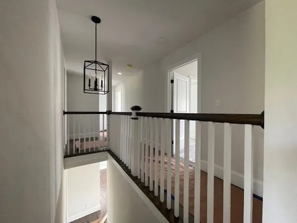 a view of staircase with railing and a chandelier