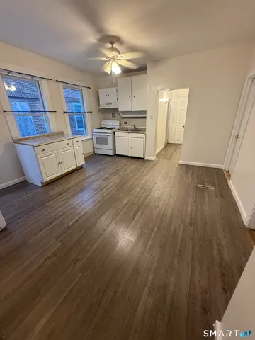 a large kitchen with cabinets wooden floor and stainless steel appliances