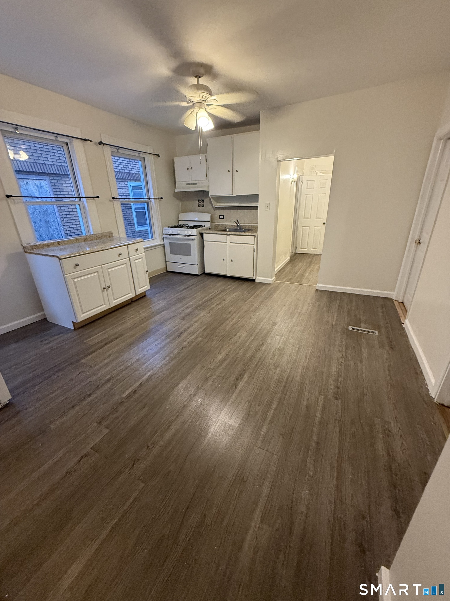 180 5th Street, Unit 1 Bridgeport, CT 06607 - Photo 14 of 26 a large kitchen with cabinets wooden floor and stainless steel appliances