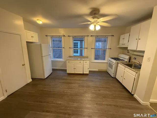 a kitchen with stainless steel appliances a refrigerator sink and white cabinets