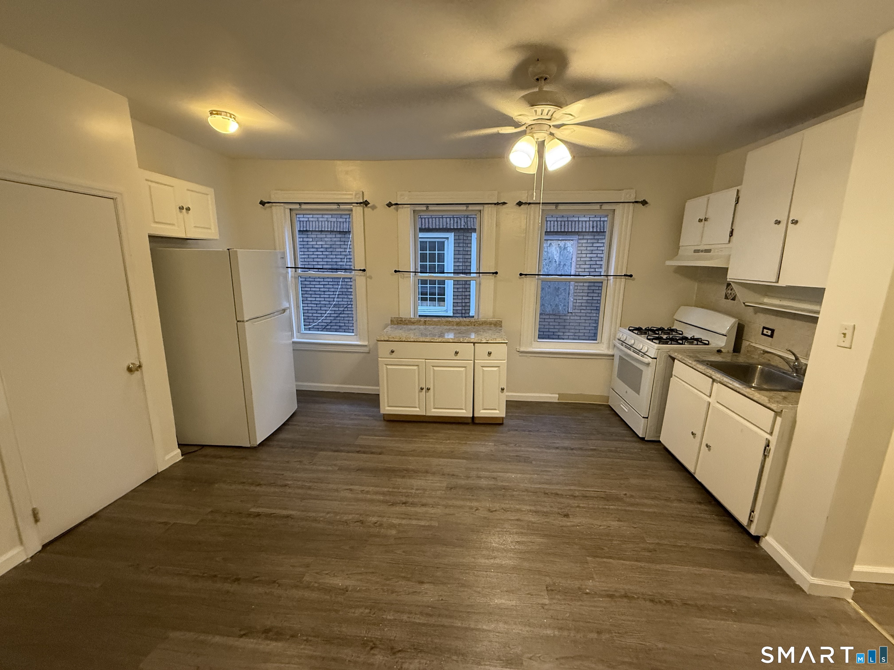 180 5th Street, Unit 1 Bridgeport, CT 06607 - Photo 15 of 26 a kitchen with stainless steel appliances a refrigerator sink and white cabinets