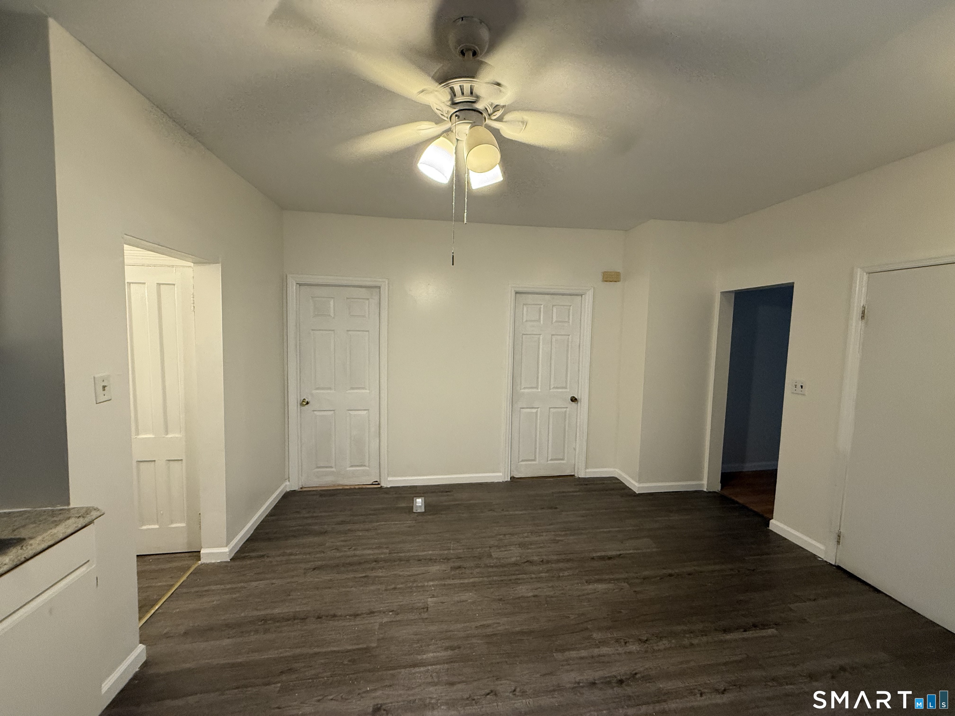 180 5th Street, Unit 1 Bridgeport, CT 06607 - Photo 17 of 26 an empty room with wooden floor and ceiling fan