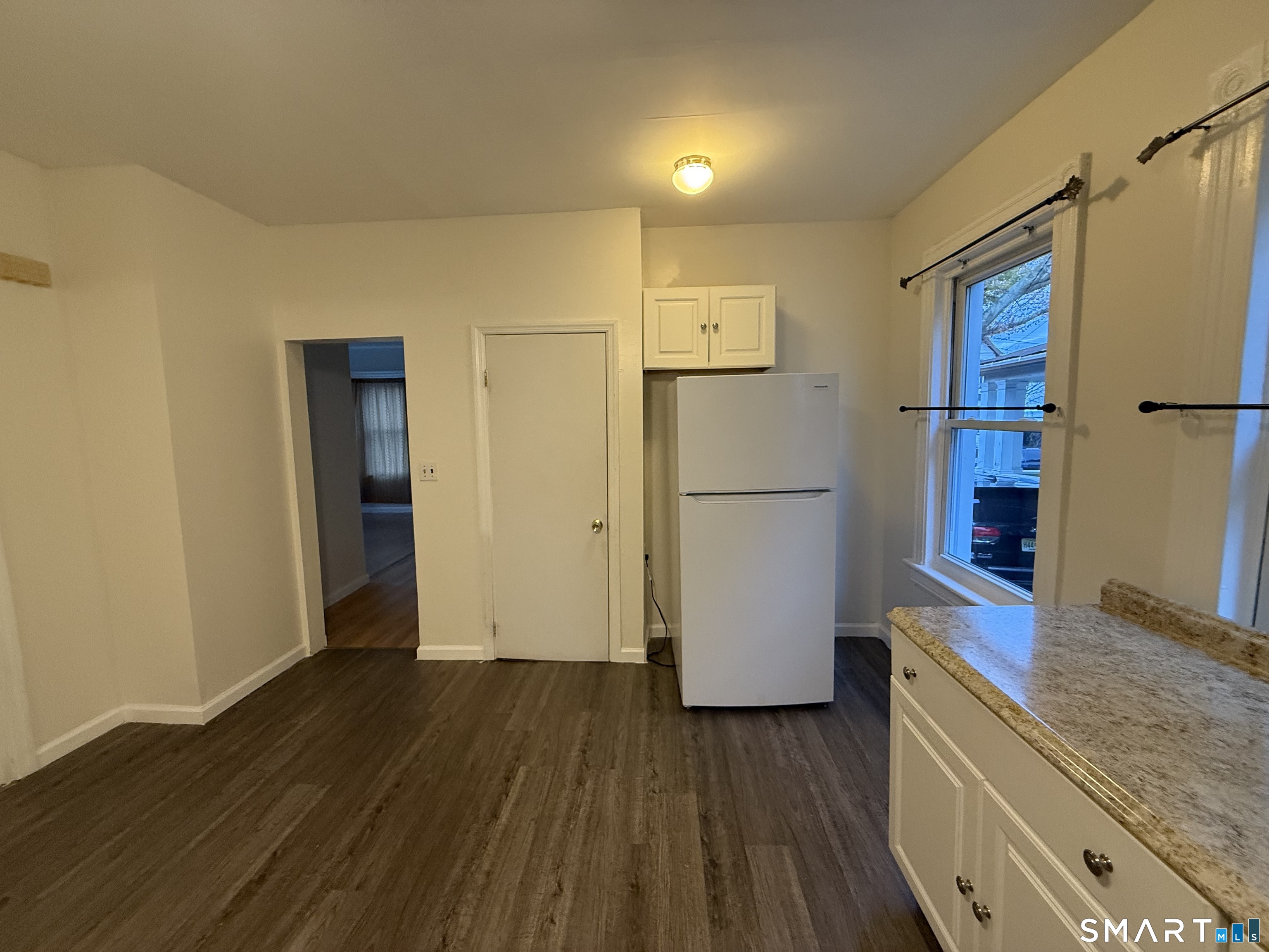 180 5th Street, Unit 1 Bridgeport, CT 06607 - Photo 18 of 26 a kitchen with a refrigerator and wooden floor