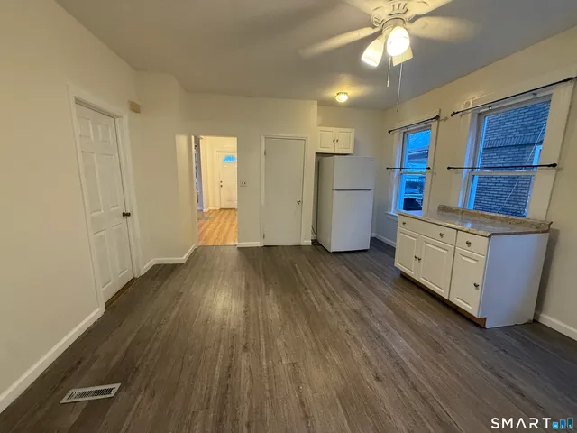 a view of a kitchen with wooden floor and electronic appliances