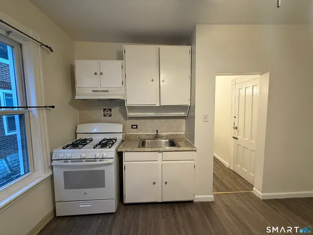a kitchen with white cabinets and white appliances