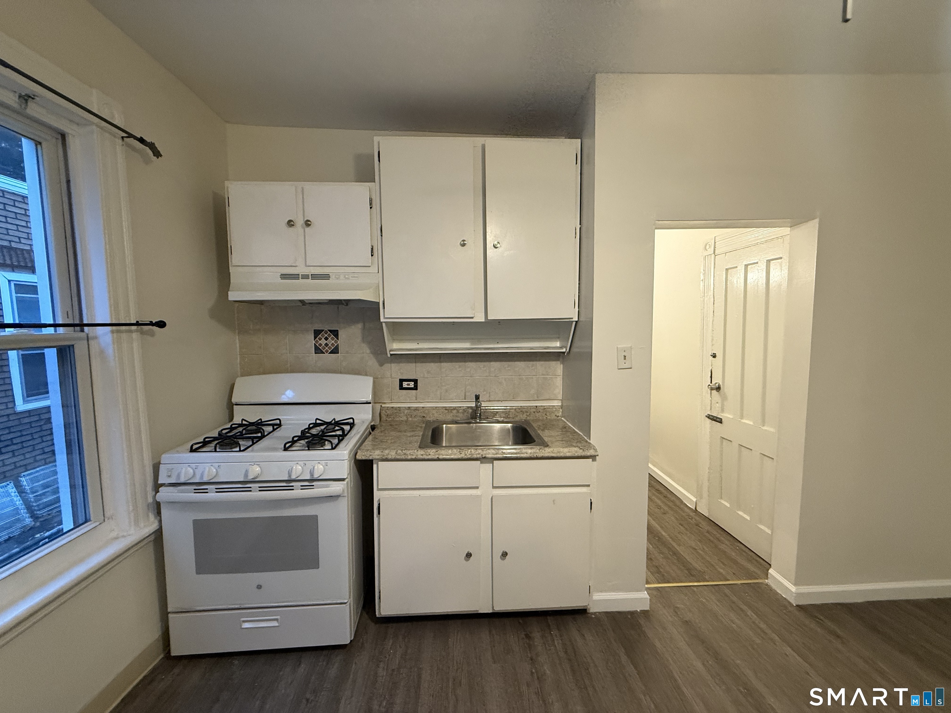 180 5th Street, Unit 1 Bridgeport, CT 06607 - Photo 21 of 26 a kitchen with white cabinets and white appliances