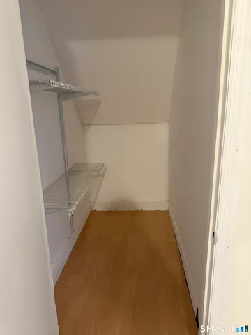 a view of walk in closet with empty racks