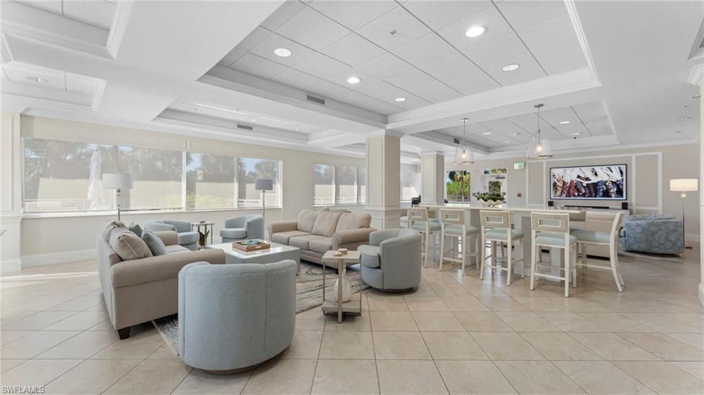 6101 Pelican Bay Boulevard, Unit 1404 Naples, FL 34108 - Photo 20 of 22 a living room with furniture and a large window