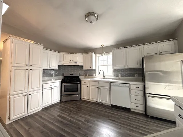 a kitchen with white cabinets and white appliances