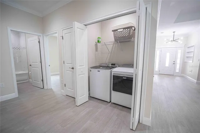 a view of a hallway with entryway and wooden floor