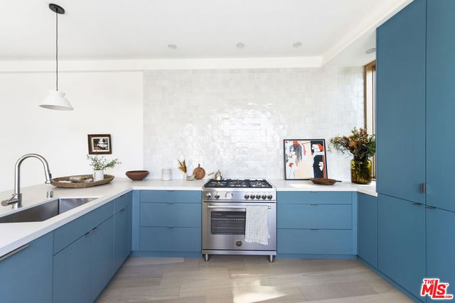 a kitchen with a stove sink and cabinets