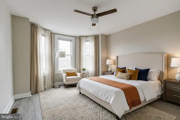 a bedroom with a bed couch and large window