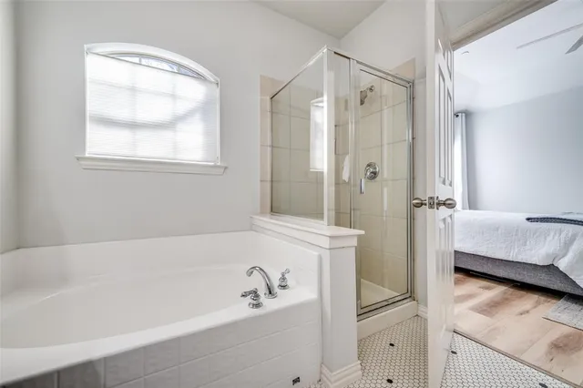 a bathroom with a tub shower vanity and a sink