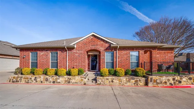 a front view of a house with lots of potted plants and a bench