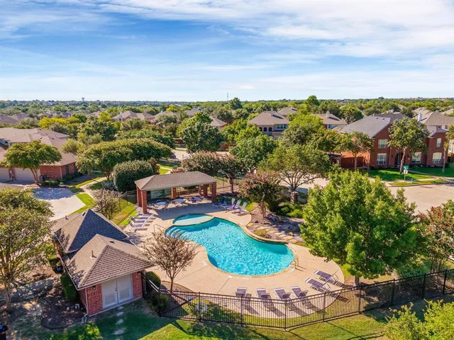 an aerial view of residential houses with outdoor space and trees