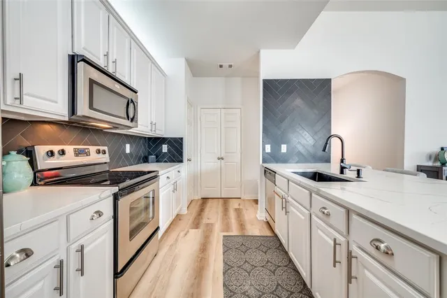 a kitchen with stainless steel appliances granite countertop a sink stove and cabinets