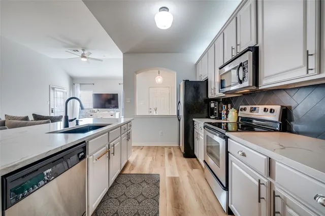 a kitchen with stainless steel appliances granite countertop a sink and cabinets