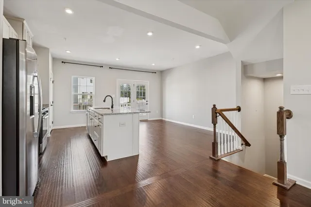a view of kitchen center island with wooden floor and electronic appliances