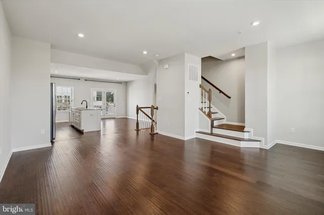 a view of an empty room with wooden floor and a cabinet