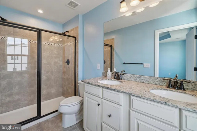 a bathroom with a granite countertop sink toilet and shower