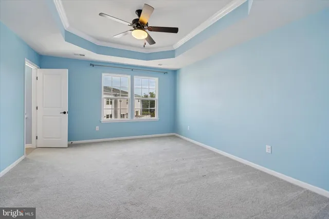 an empty room with windows and ceiling fan