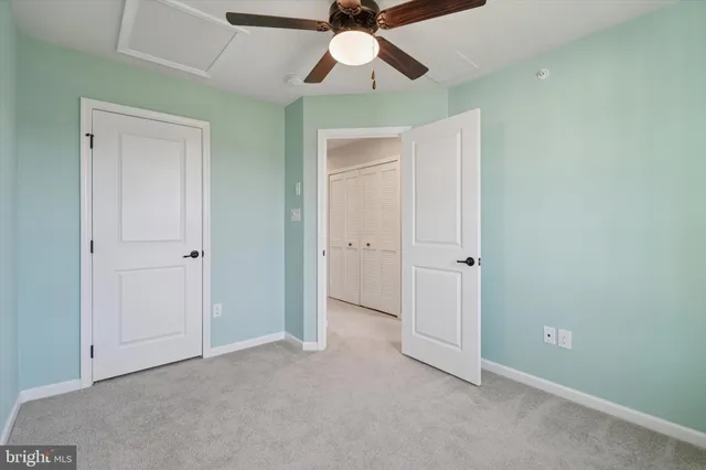 an empty room with chandelier fan