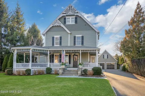 a front view of a house with a yard and trees