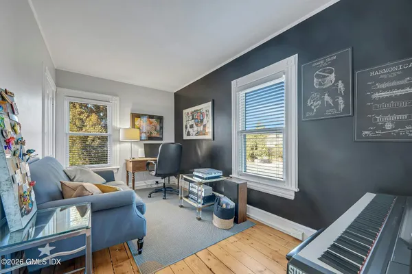 a bedroom with a bed next to a window with pc on the wall