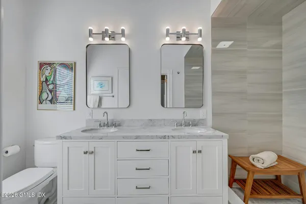 a bedroom with a bed and a lamp on the dresser