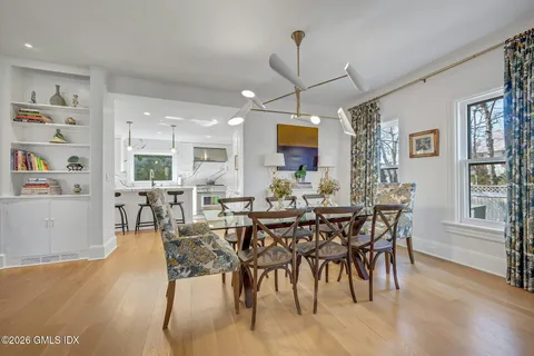 a kitchen with a dining table chairs sink and cabinets