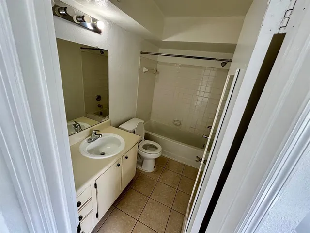 a bathroom with a double vanity sink and mirror with toilet