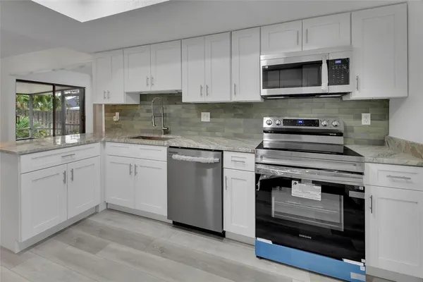 a kitchen with white cabinets stainless steel appliances and sink