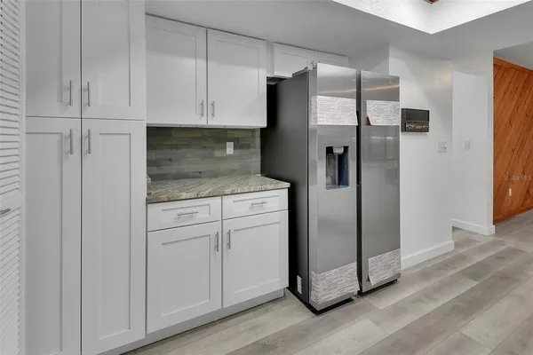 a kitchen with stainless steel appliances granite countertop white cabinets and refrigerator